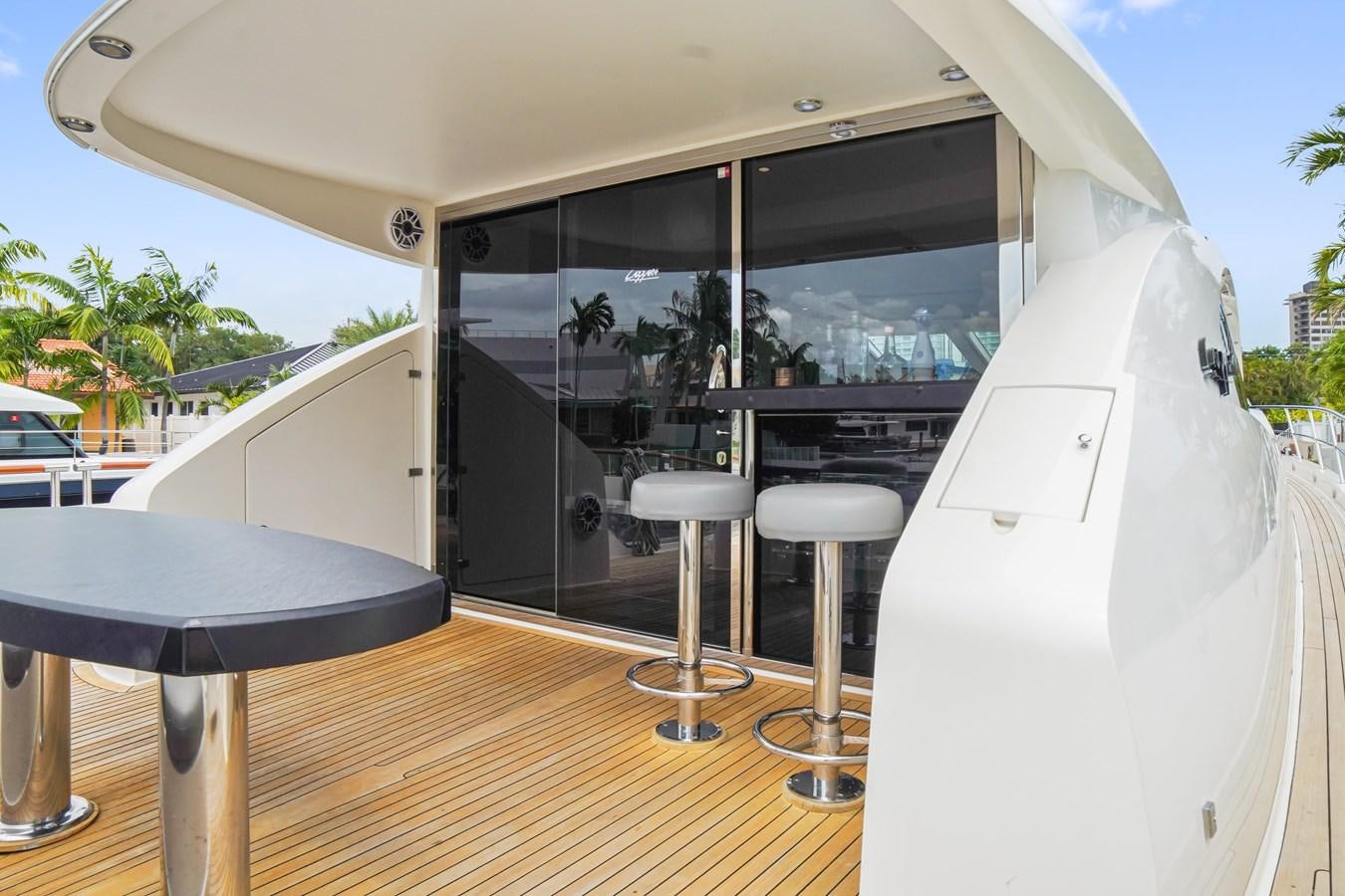 a room with a table and stools and a large window aboard LAZZARA 68' Yacht for Sale