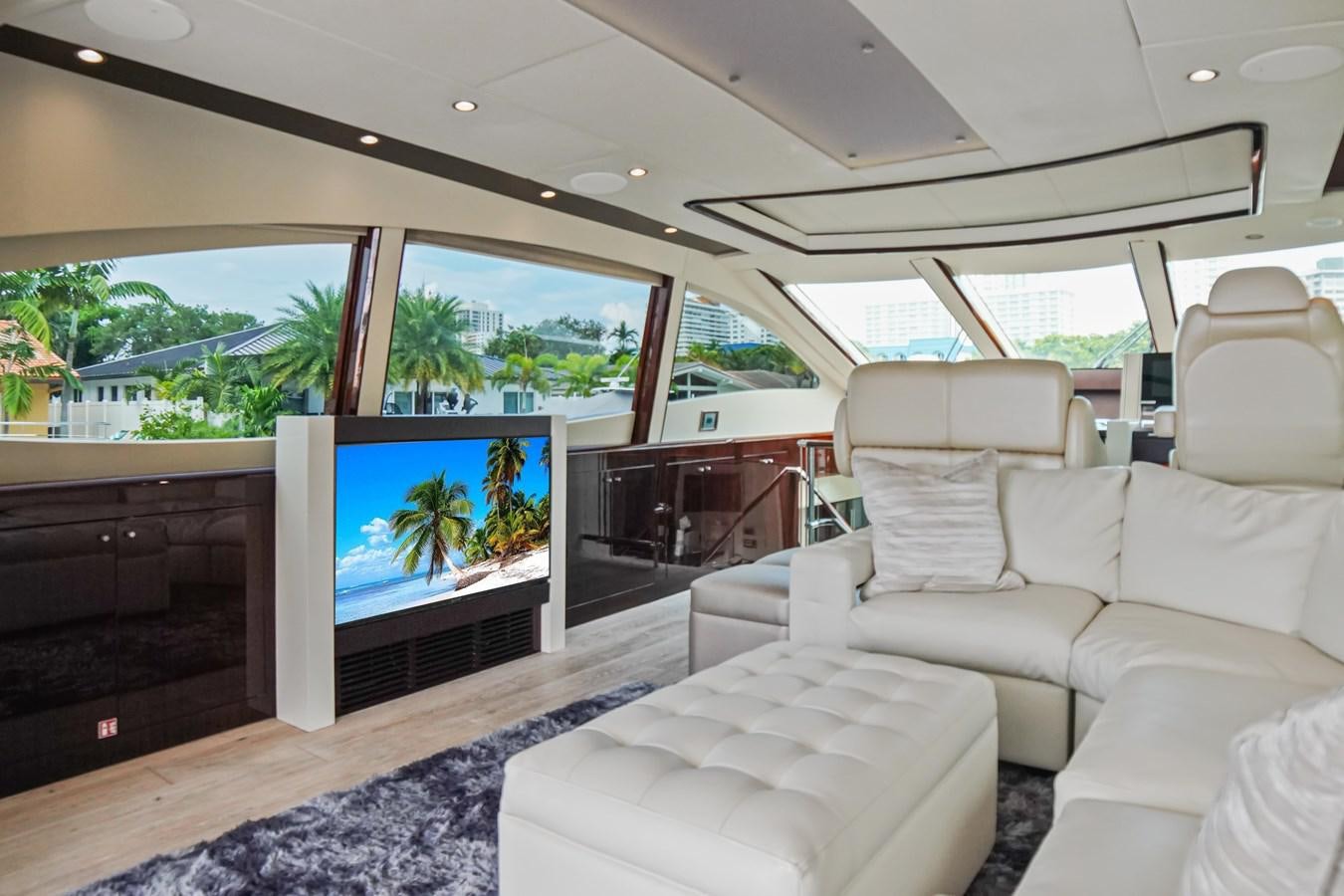 a living room with a large screen aboard LAZZARA 68' Yacht for Sale