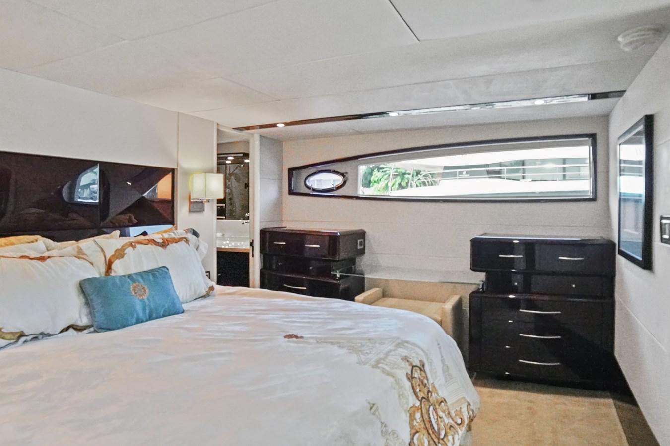 a bedroom with a bed and a dresser aboard LAZZARA 68' Yacht for Sale