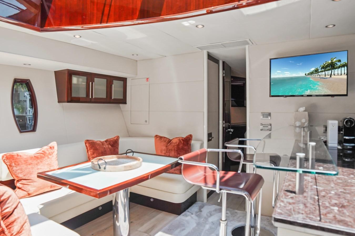 a living room with a table and chairs aboard LAZZARA 68' Yacht for Sale