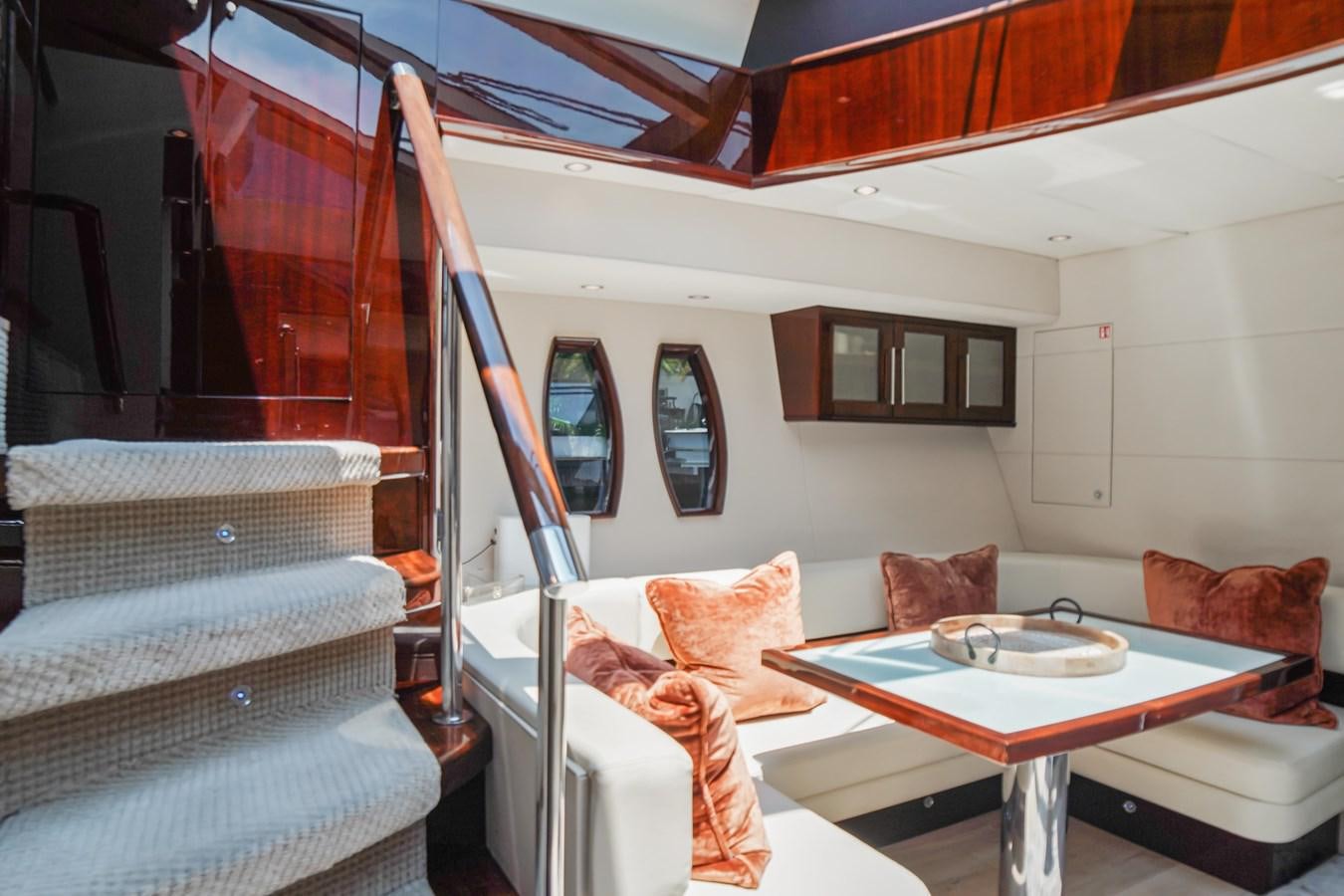 a living room with a bed and a table aboard LAZZARA 68' Yacht for Sale