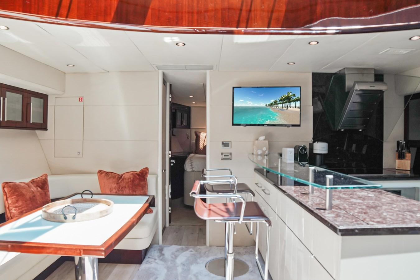 a kitchen with a bar and a table aboard LAZZARA 68' Yacht for Sale