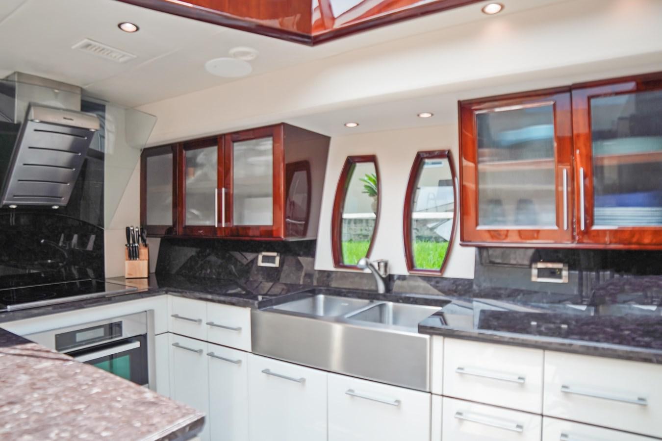 a kitchen with wooden cabinets aboard LAZZARA 68' Yacht for Sale