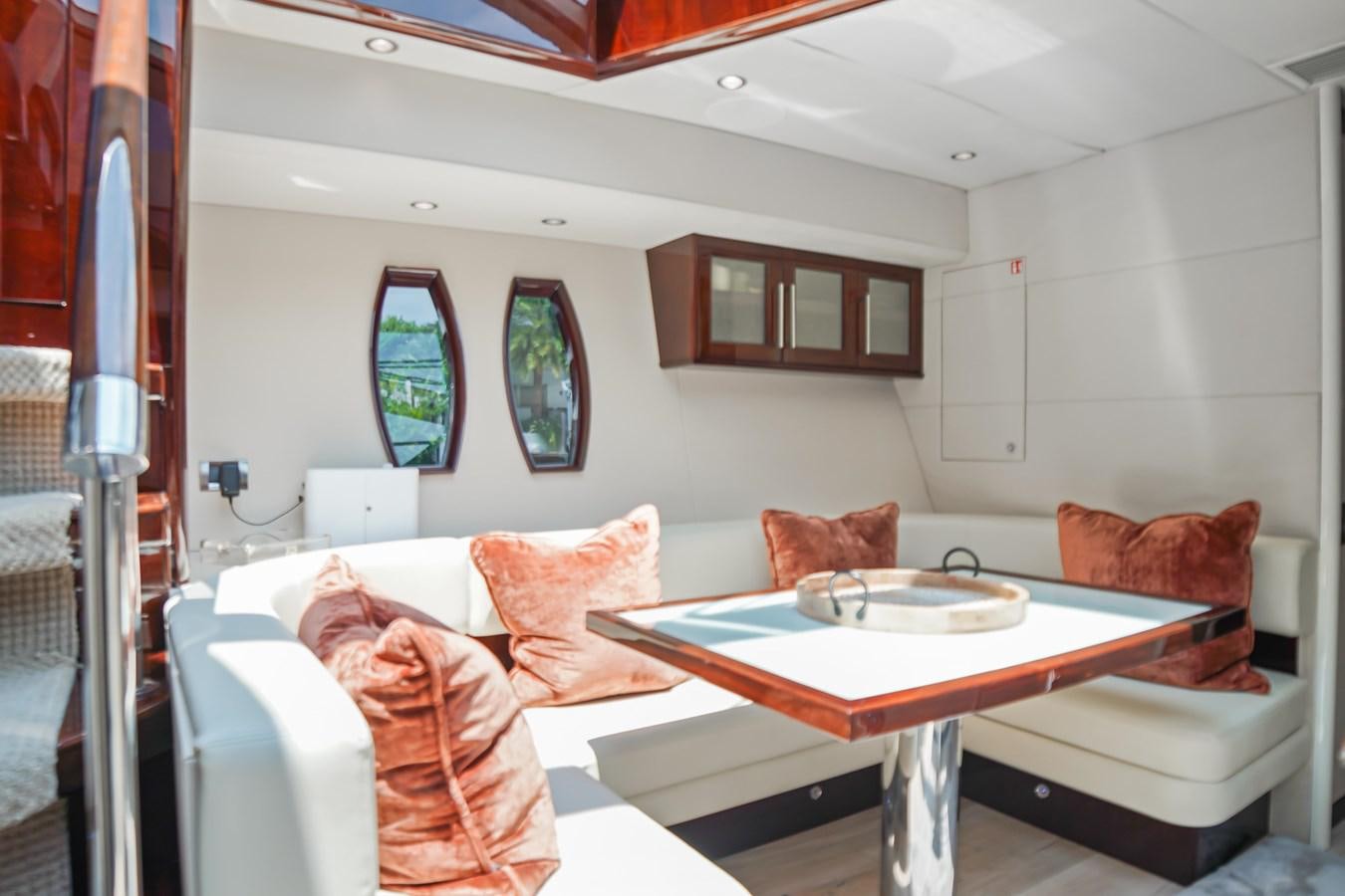 a living room with a table and chairs aboard LAZZARA 68' Yacht for Sale