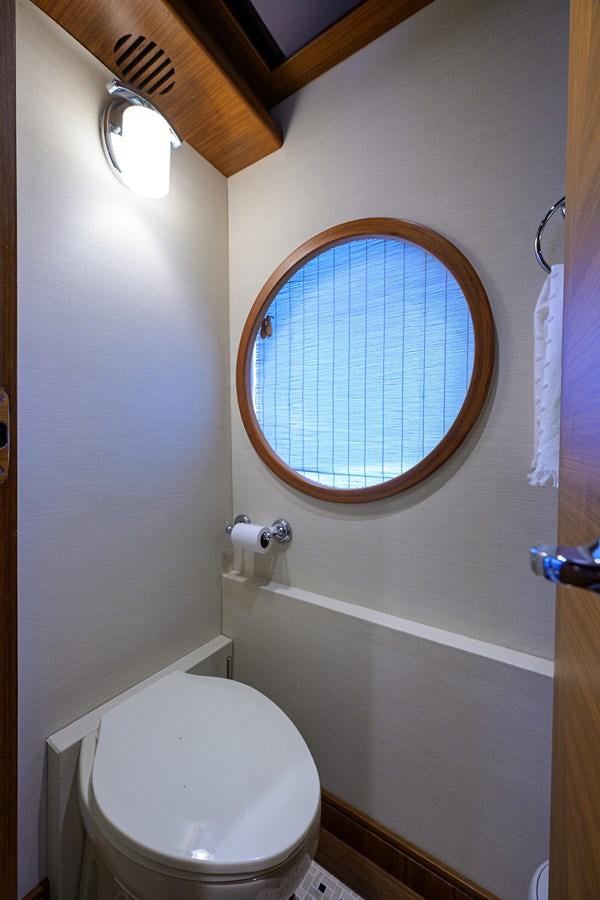 a bathroom with a toilet and a window aboard ST. TROPEZ Yacht for Sale
