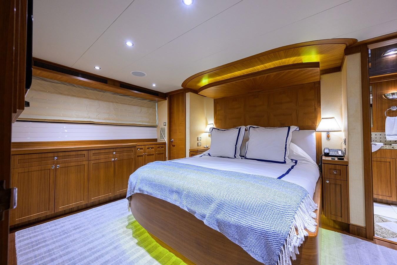 a bedroom with a bed and a lamp aboard ST. TROPEZ Yacht for Sale