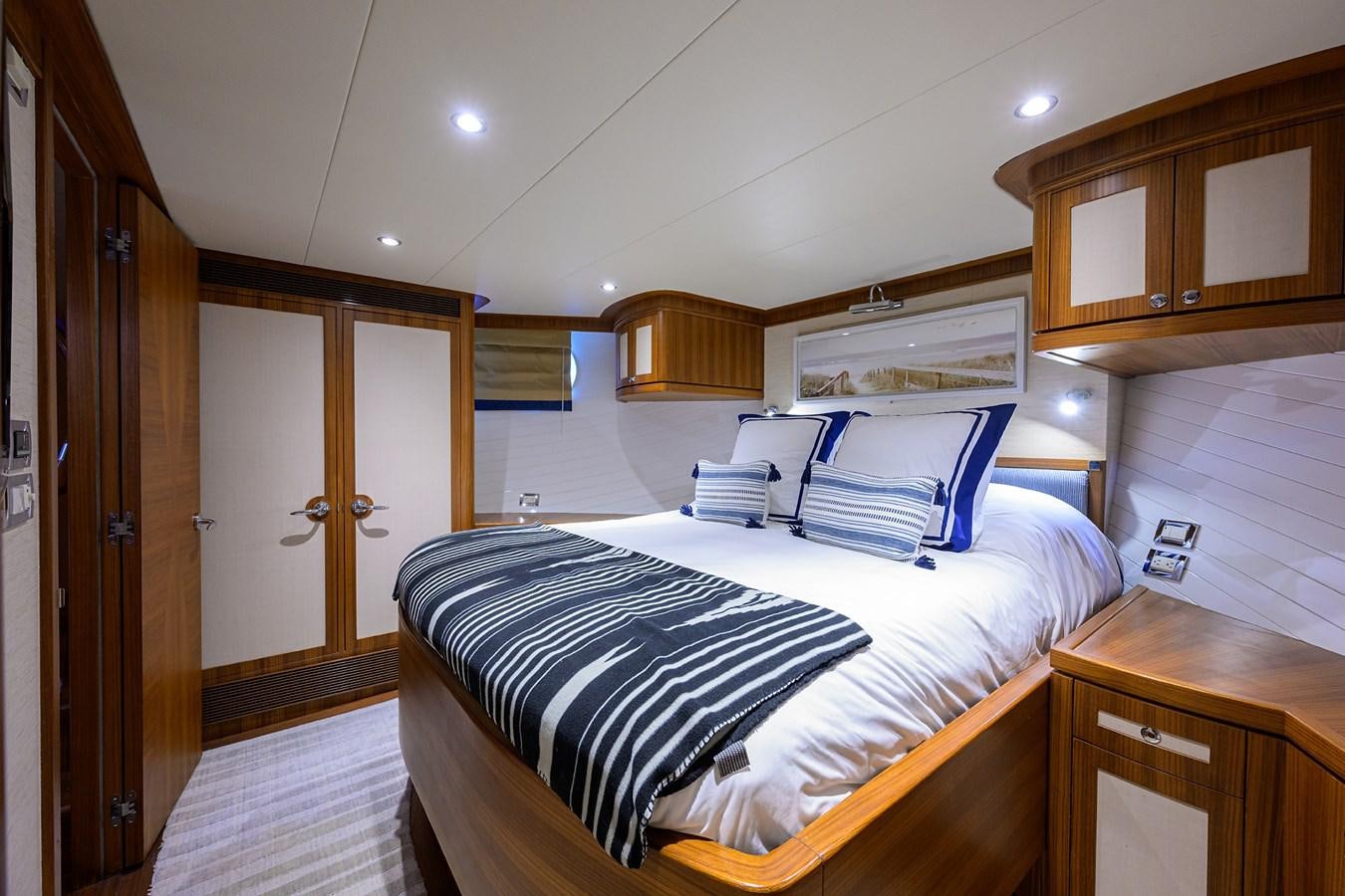 a bedroom with a bed and cabinets aboard ST. TROPEZ Yacht for Sale