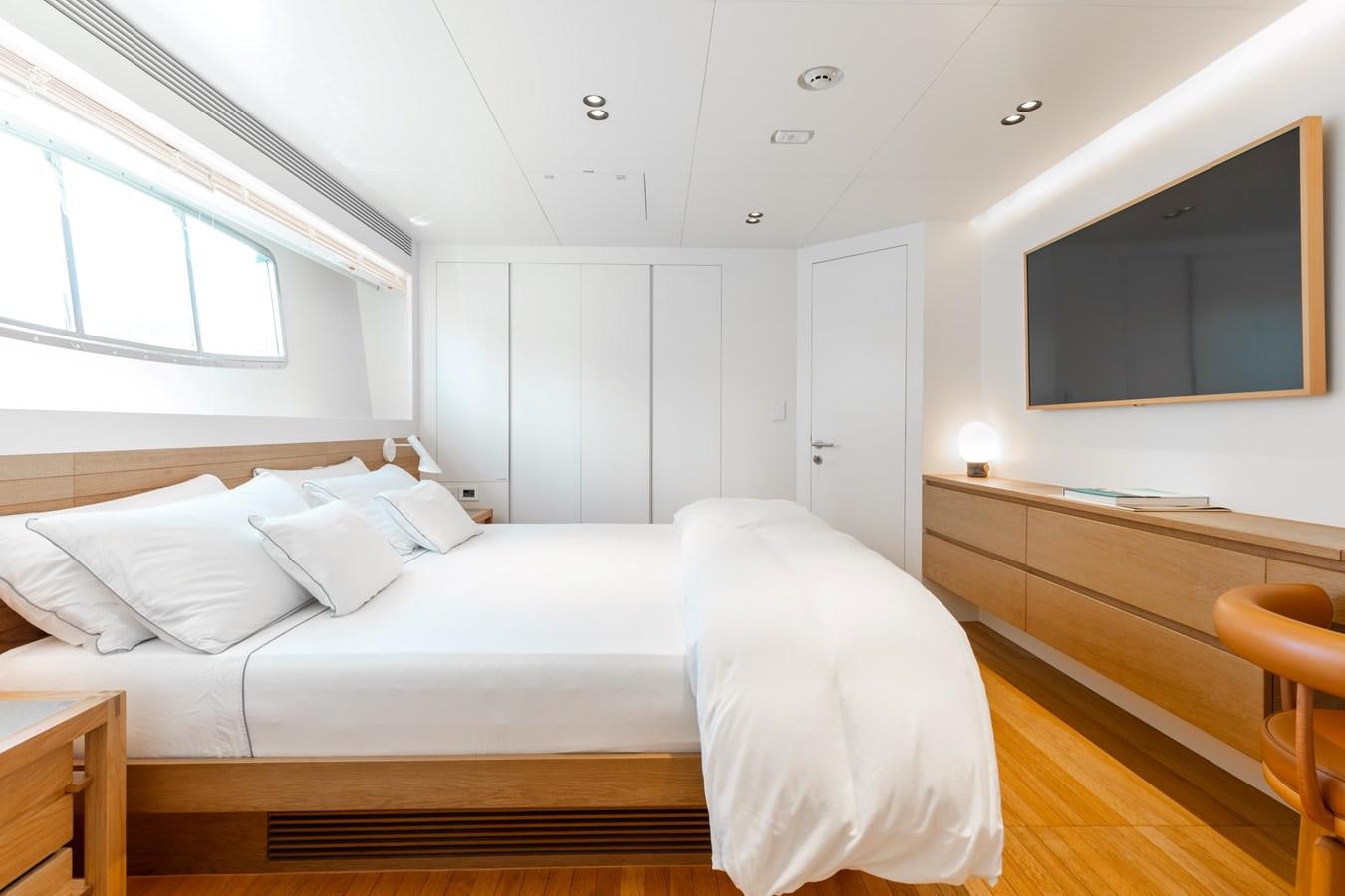 a bedroom with a bed and a desk aboard ADAGIO Yacht for Sale
