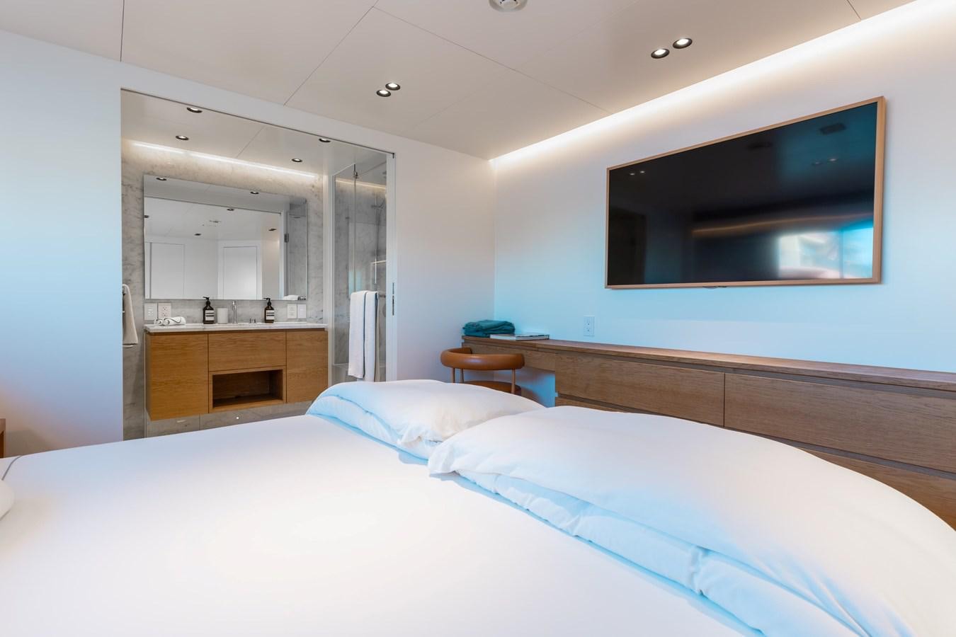 a bedroom with a bed and a tv on the wall aboard ADAGIO Yacht for Sale