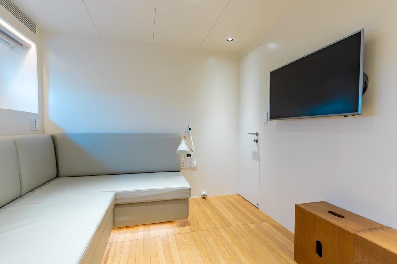 a room with a couch and a tv on the wall aboard ADAGIO Yacht for Sale