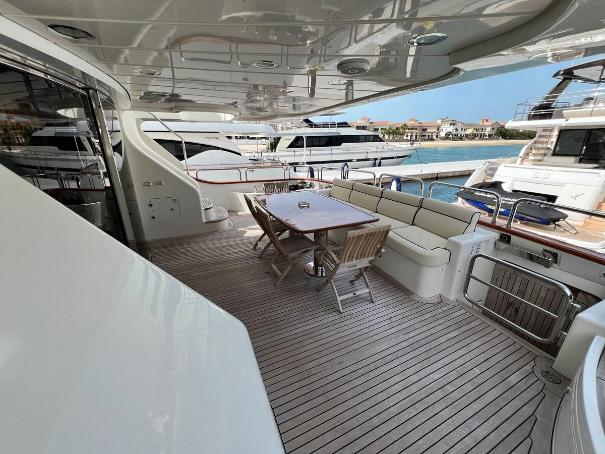 a deck with a table and chairs aboard BENETTI 100 Yacht for Sale