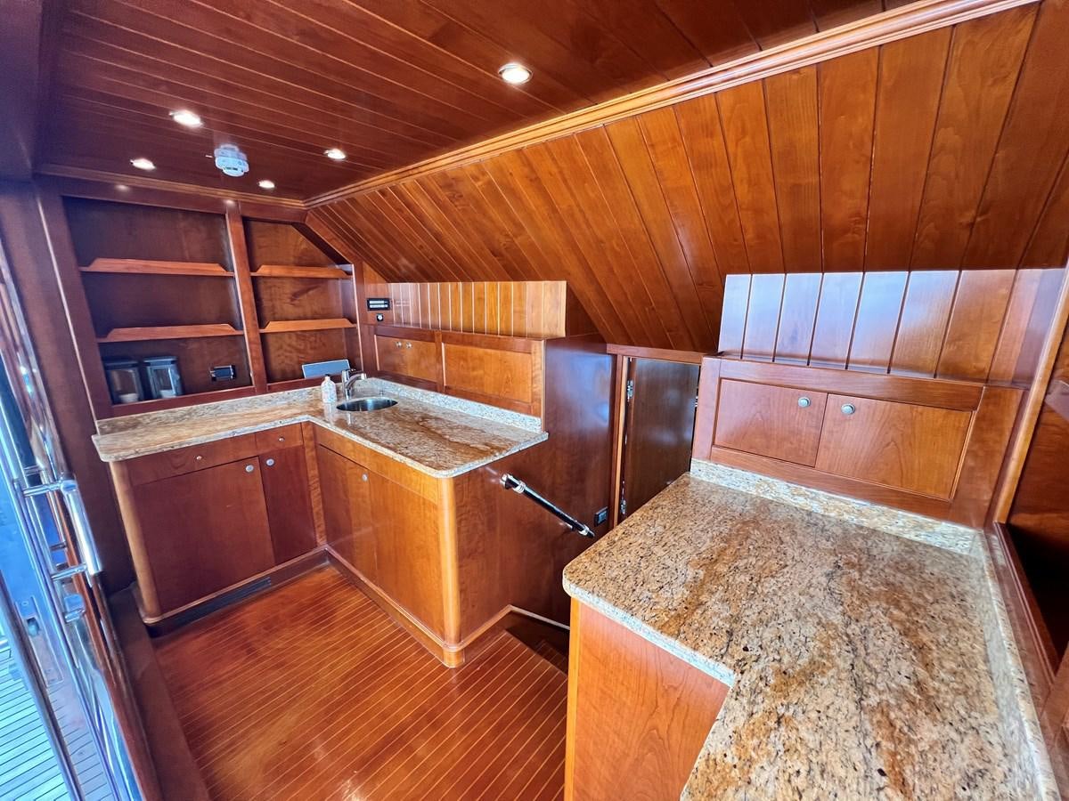 a kitchen with wooden cabinets aboard BENETTI 100 Yacht for Sale