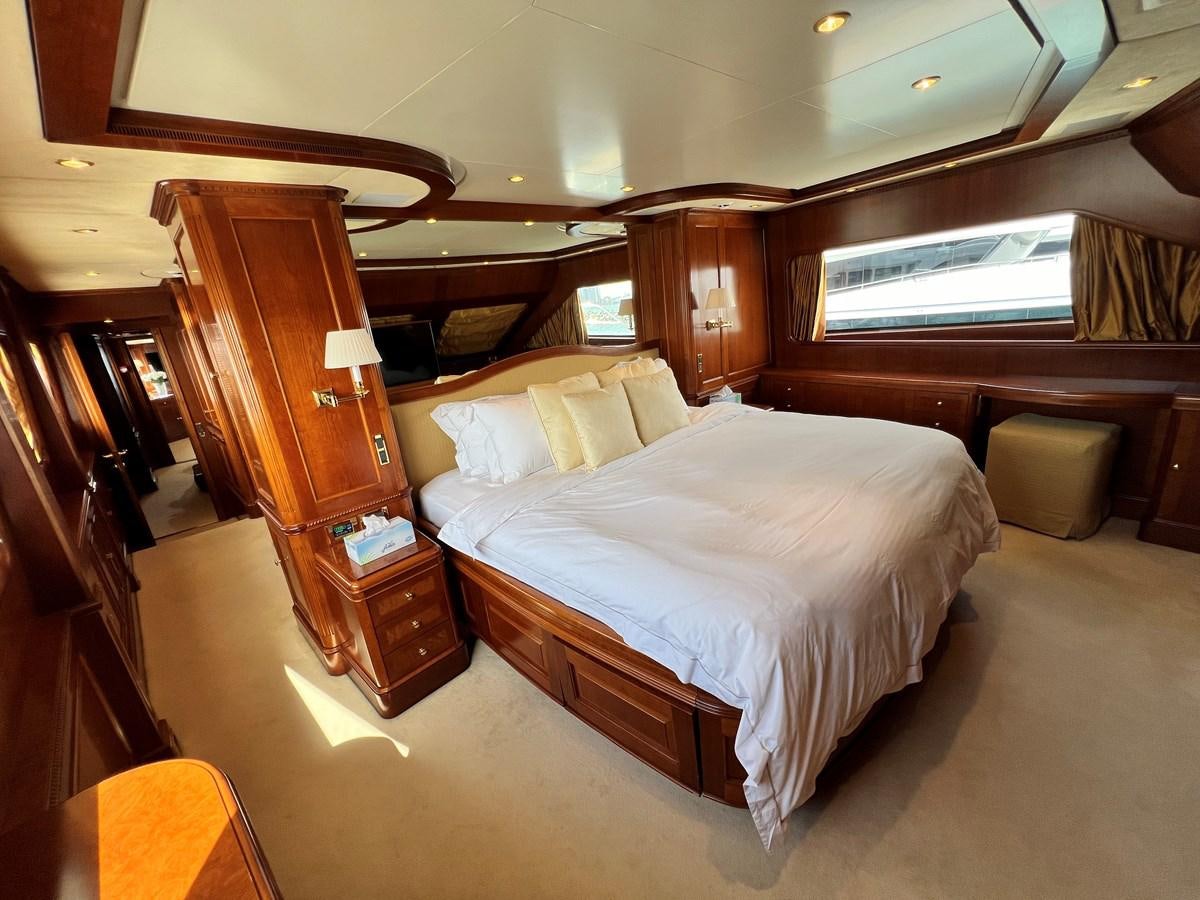 a bedroom with a bed and a chair aboard BENETTI 100 Yacht for Sale