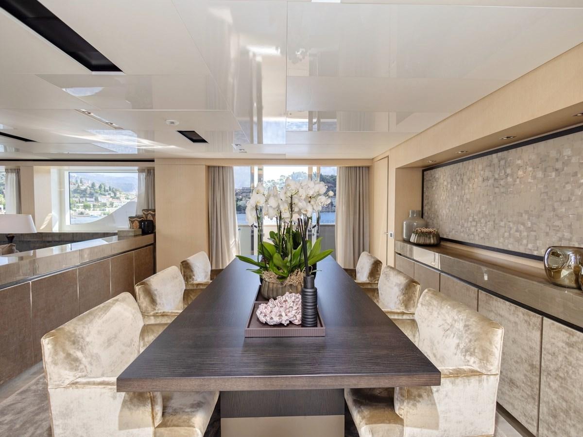 a living room with a table and couches aboard MOCEAN II Yacht for Sale