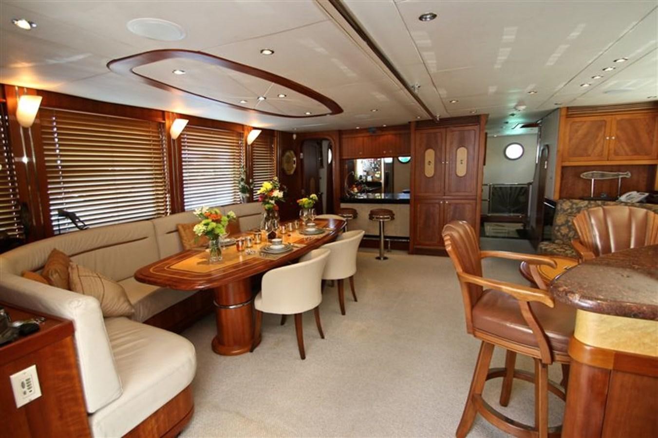 a living room with a dining table and chairs aboard IMPETUS Yacht for Sale