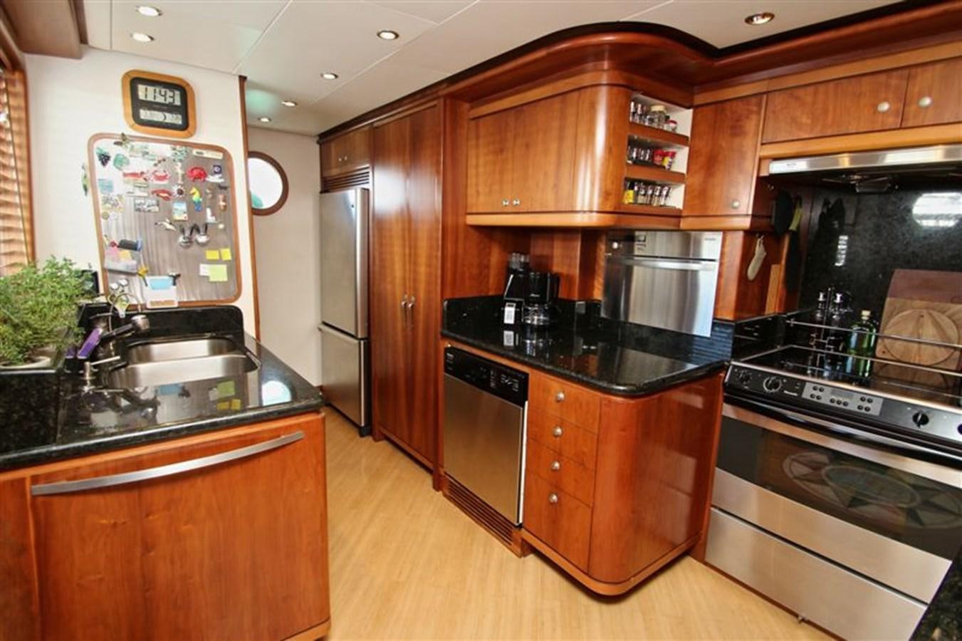 a kitchen with wooden cabinets aboard IMPETUS Yacht for Sale
