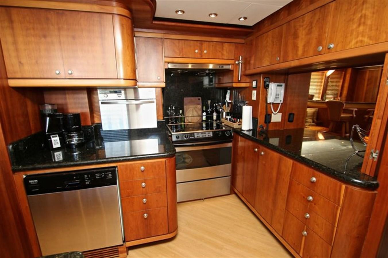 a kitchen with wooden cabinets aboard IMPETUS Yacht for Sale