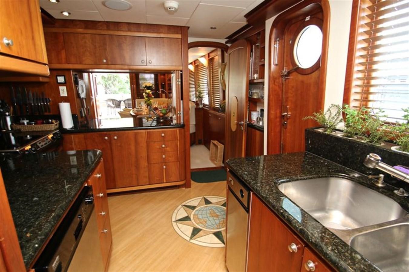 a kitchen with wooden cabinets aboard IMPETUS Yacht for Sale