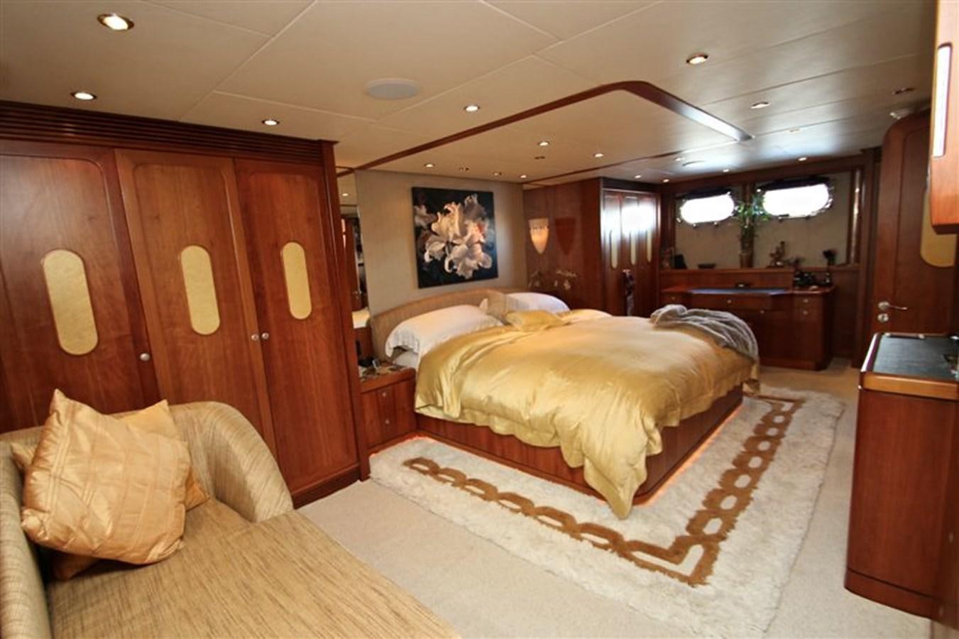 a bedroom with a bed and a wood cabinet aboard IMPETUS Yacht for Sale
