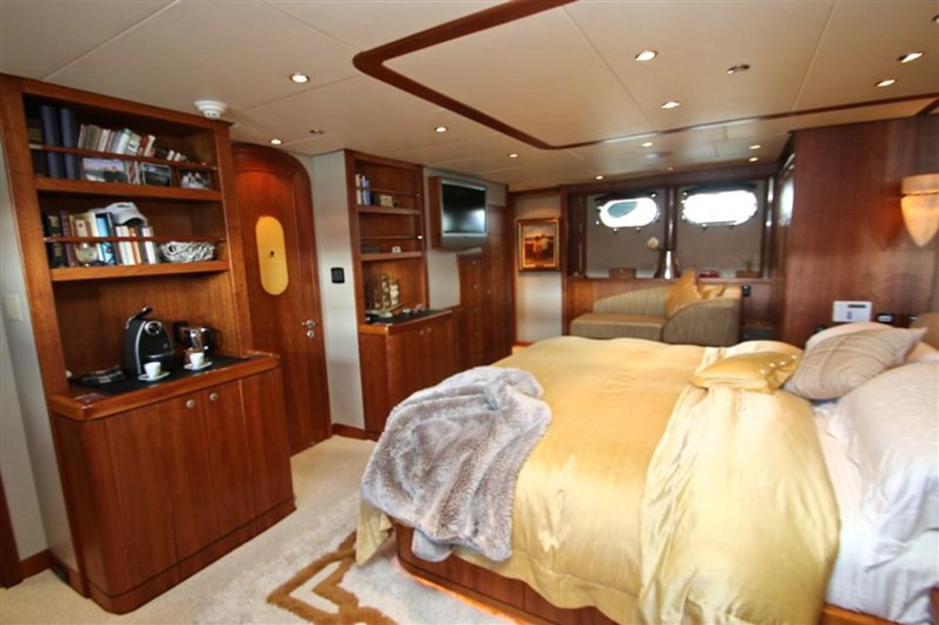 a bedroom with a bed and a bookcase aboard IMPETUS Yacht for Sale