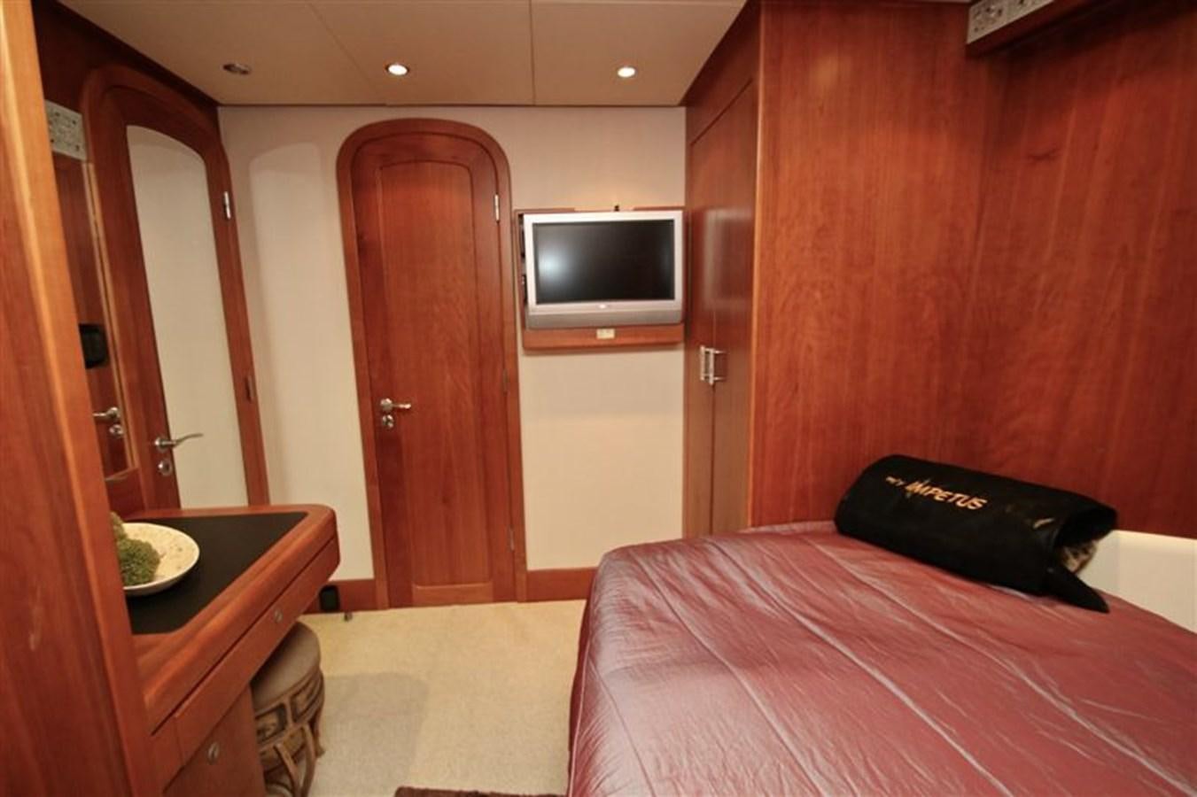 a bedroom with a bed and a television aboard IMPETUS Yacht for Sale