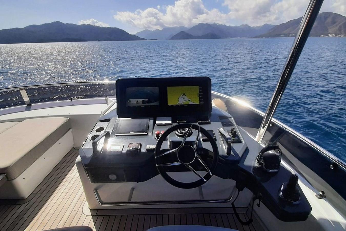 a boat with a steering wheel and a view of mountains and water aboard SIRENA 68 Yacht for Sale