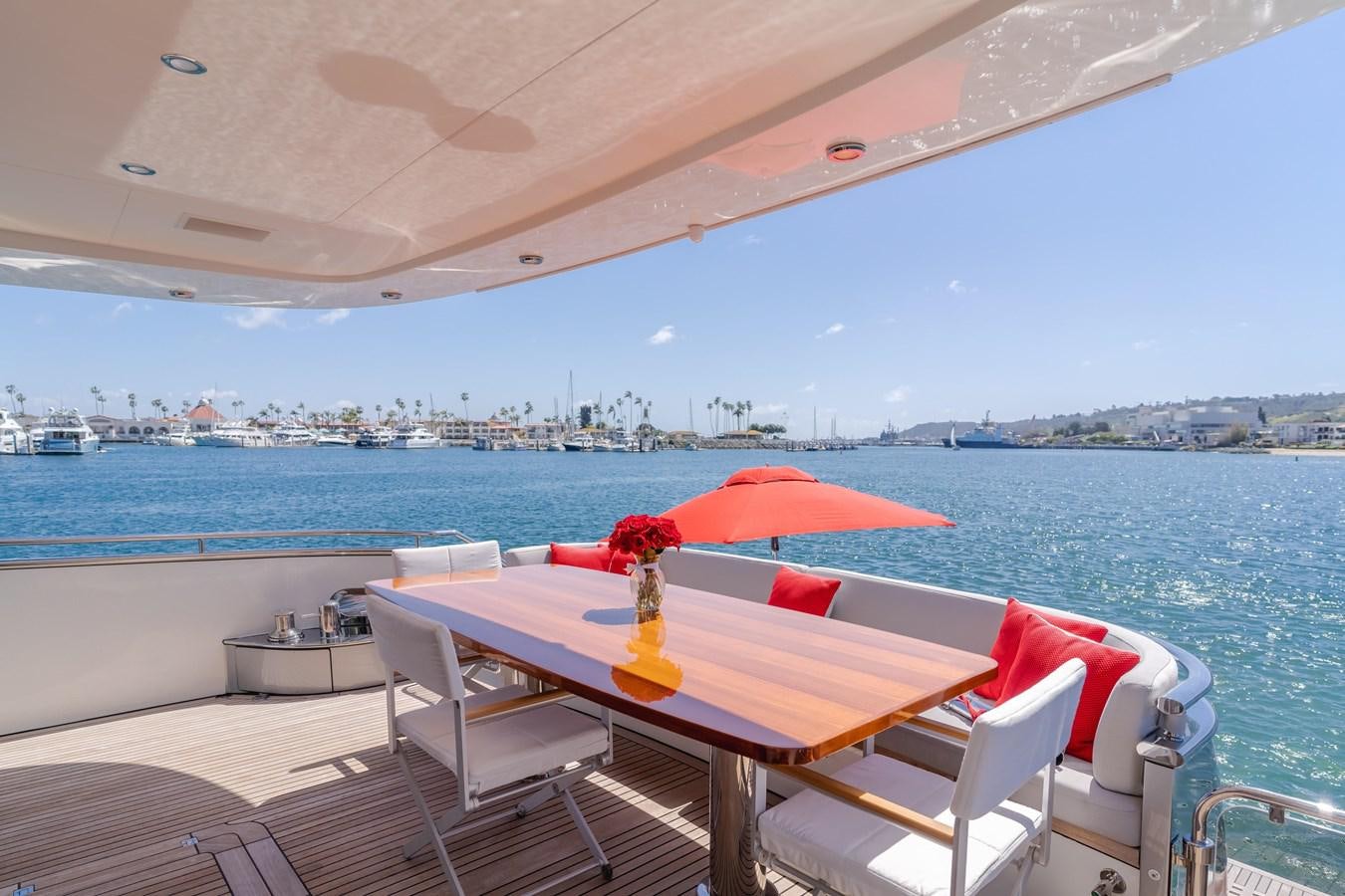 a table and chairs on a deck overlooking a body of water aboard GYRFALCON Yacht for Sale