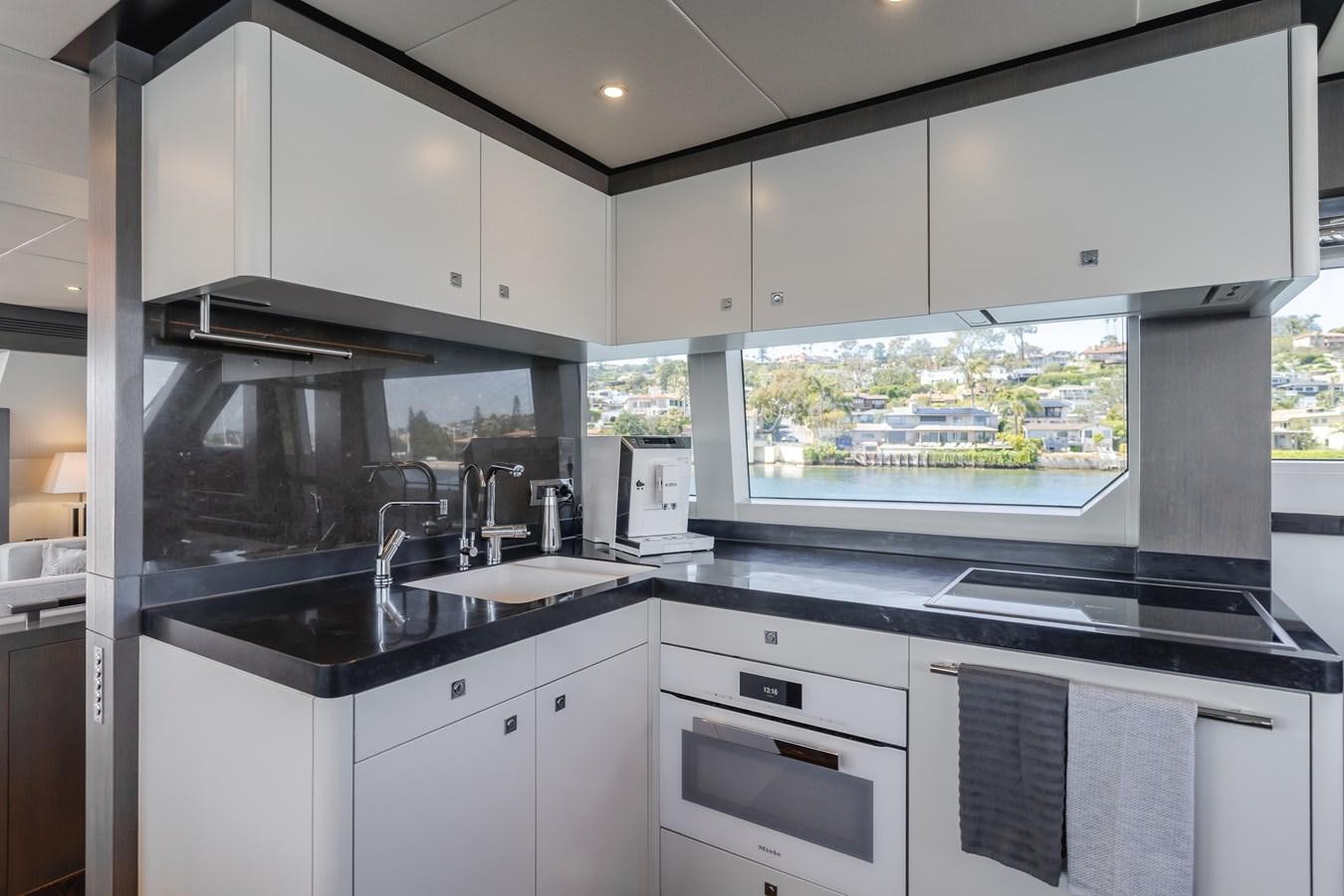 a kitchen with white cabinets aboard GYRFALCON Yacht for Sale