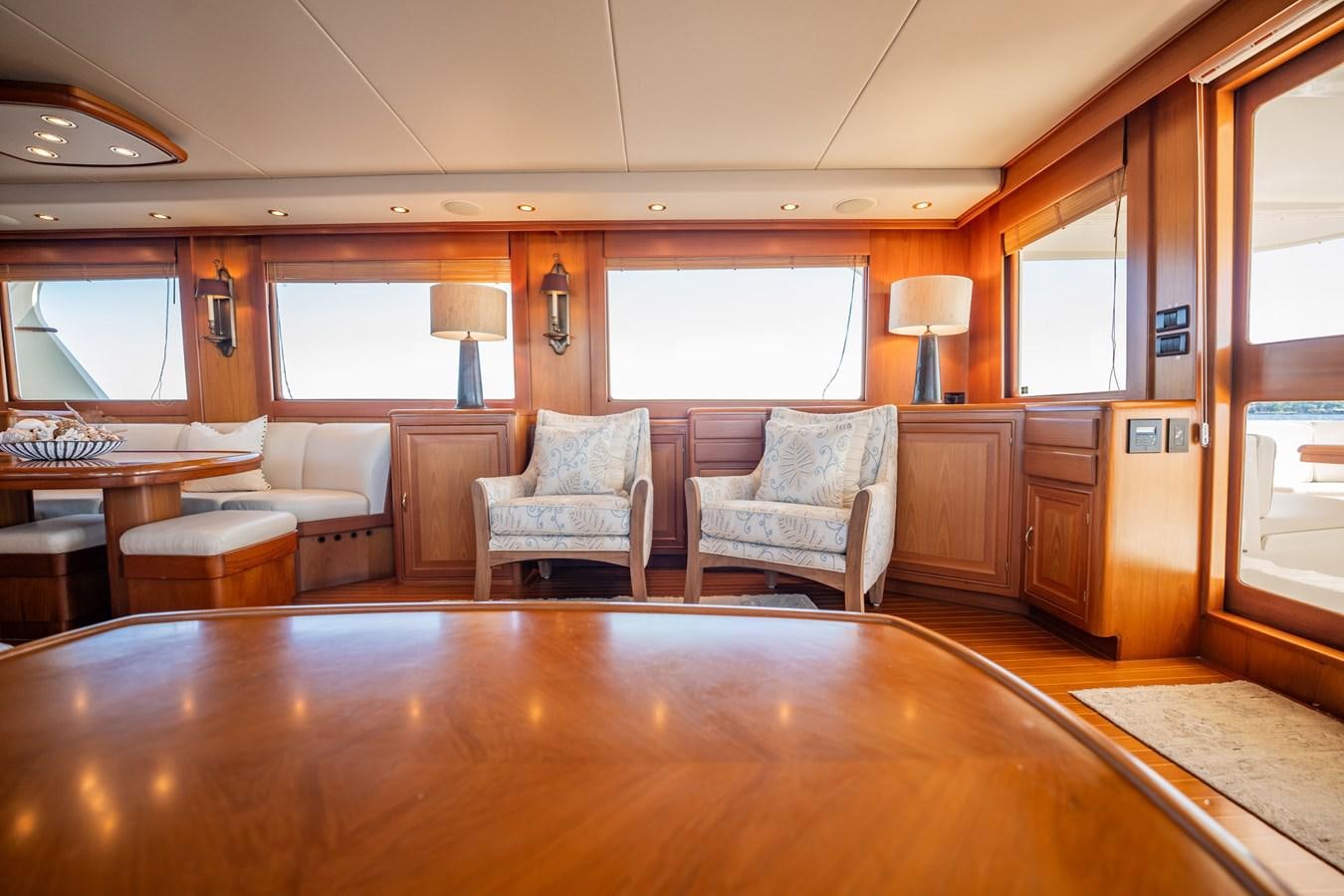 a large living room with a wood table and chairs aboard BEBA Yacht for Sale