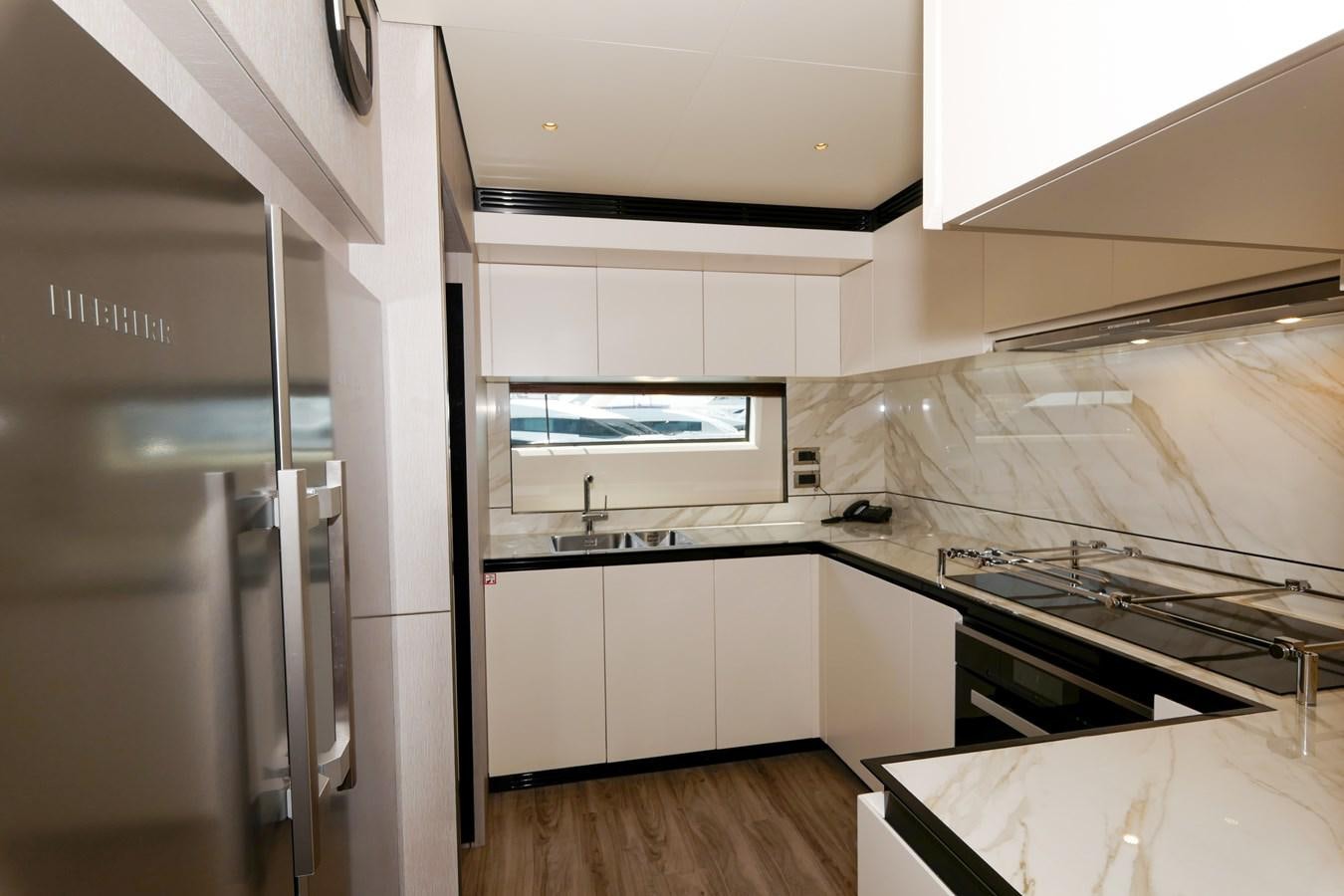 a kitchen with white cabinets aboard IRYNA Yacht for Sale