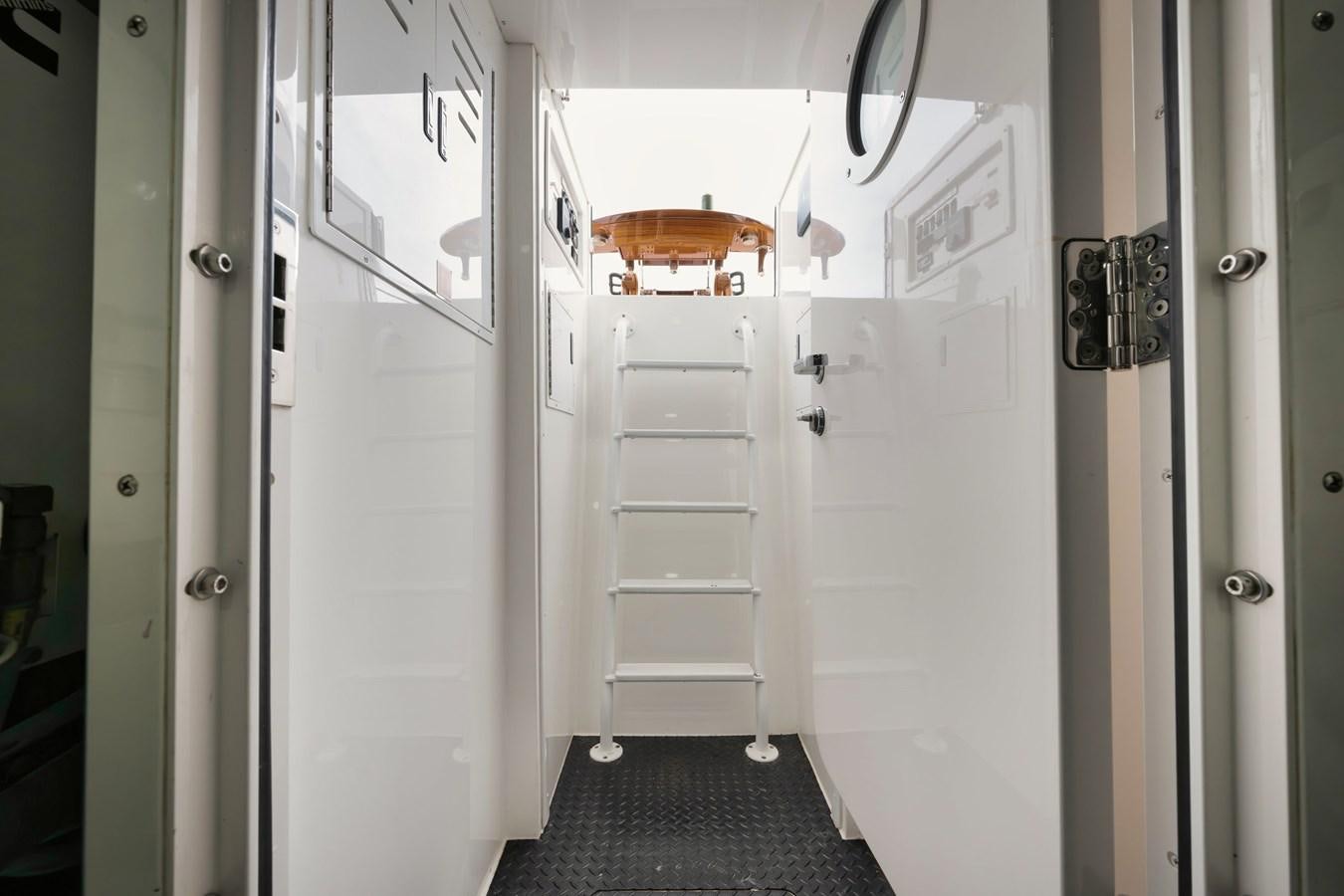 a room with a white door and a metal rack with doors aboard COOKIE MONSTER Yacht for Sale