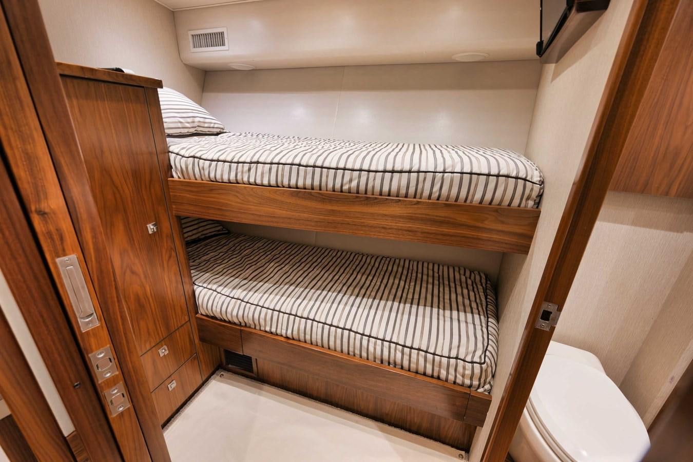 a bunk bed with a wood headboard aboard COOKIE MONSTER Yacht for Sale