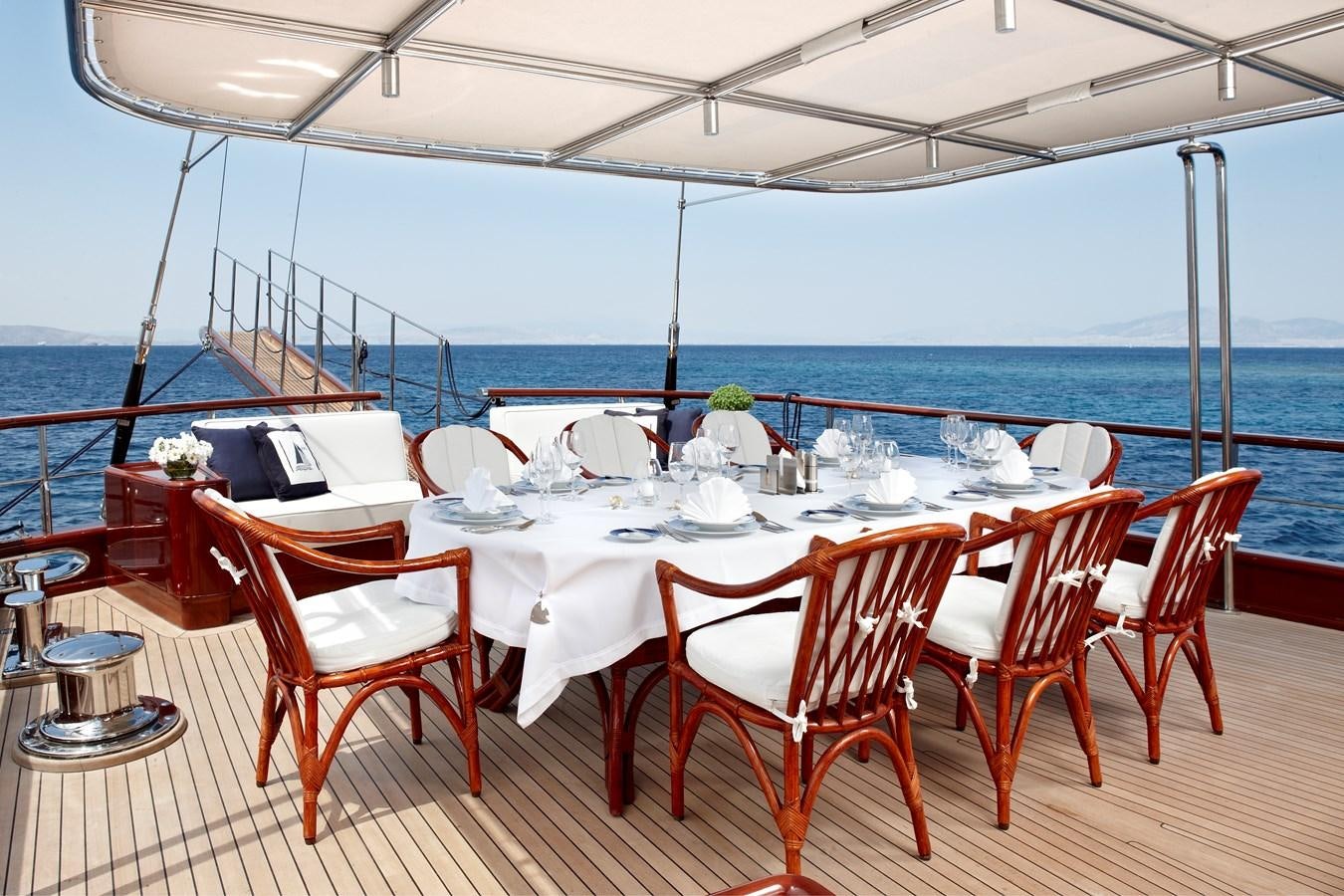 a table set for a dinner on a deck overlooking the ocean aboard IRAKLIS L Yacht for Sale