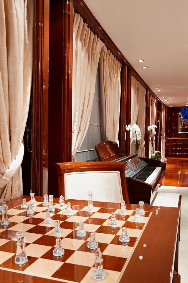 a piano and a table with candles aboard IRAKLIS L Yacht for Sale