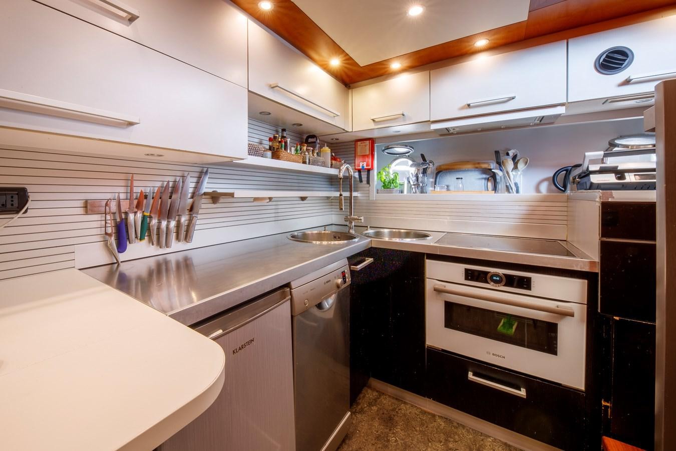 a kitchen with white cabinets aboard TRUE AUSTRIAN Yacht for Sale