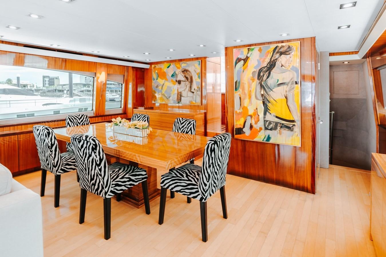 a room with a table and chairs aboard HATTERAS 105 Yacht for Sale