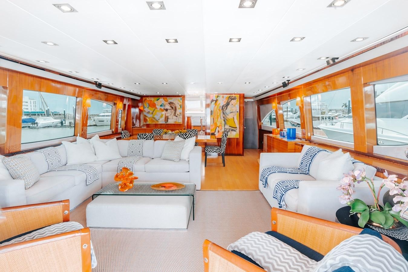 a living room with a white couch and a large window aboard HATTERAS 105 Yacht for Sale