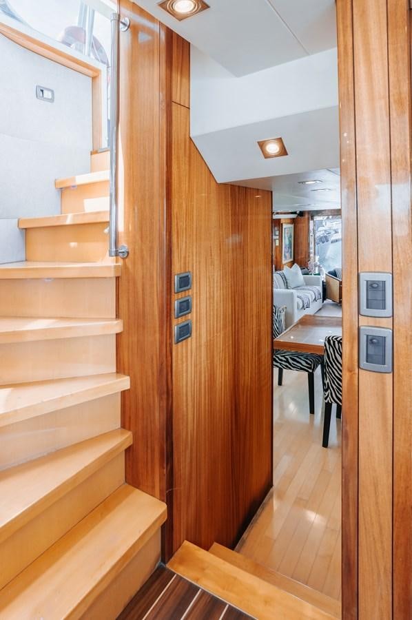 a wood staircase in a room aboard HATTERAS 105 Yacht for Sale