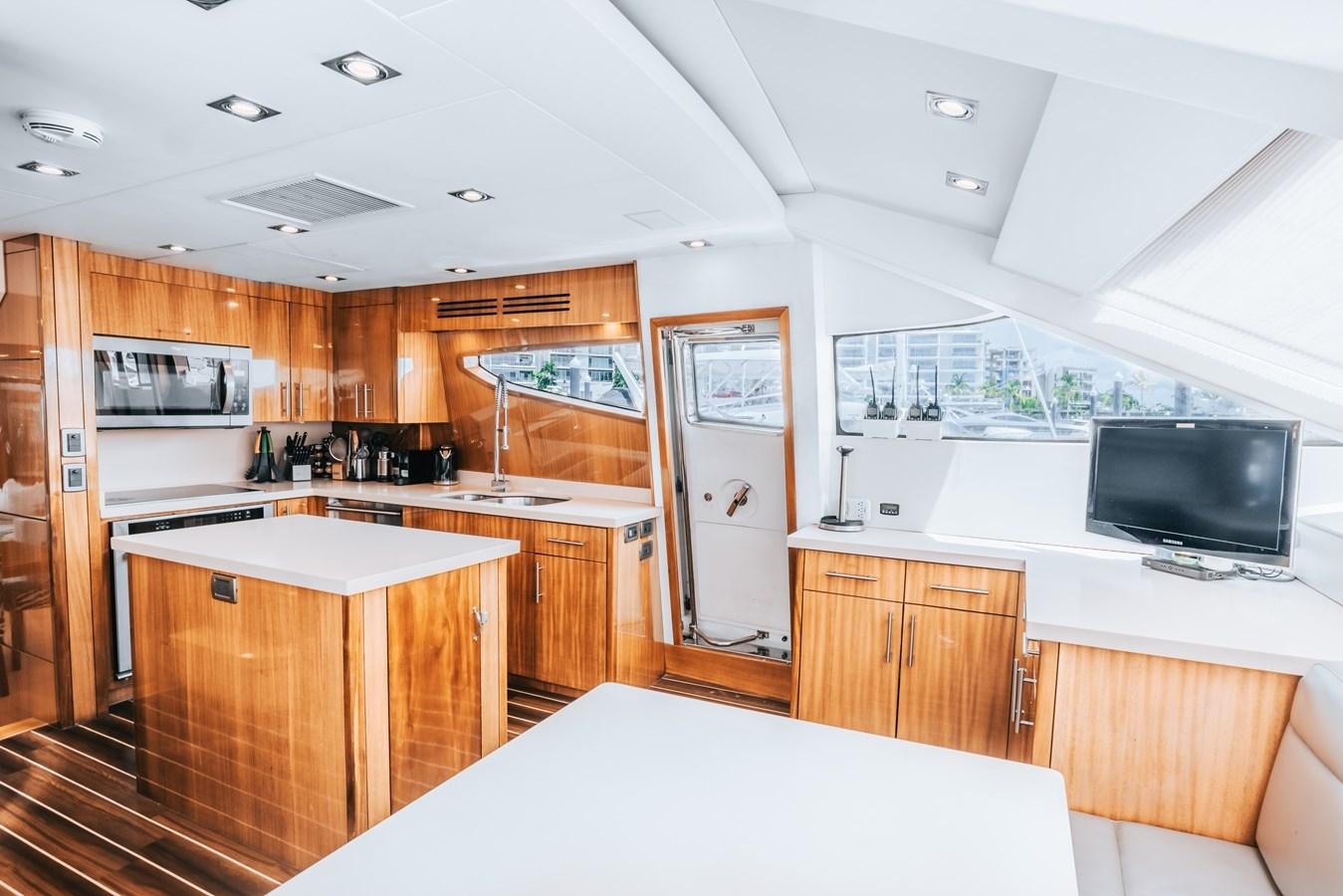 a kitchen with a large window aboard HATTERAS 105 Yacht for Sale