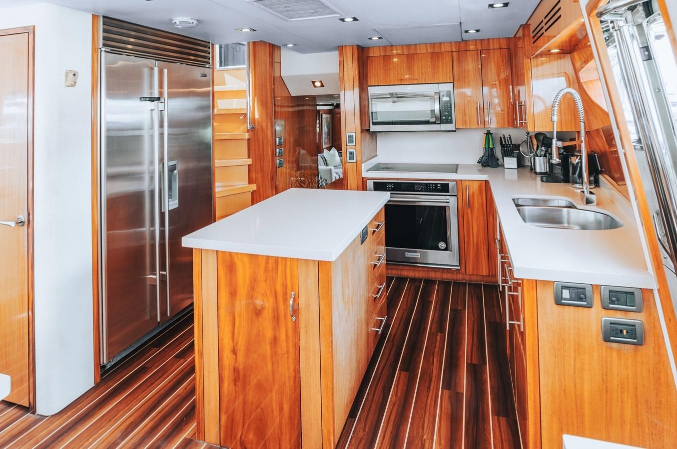 a kitchen with wooden cabinets aboard HATTERAS 105 Yacht for Sale