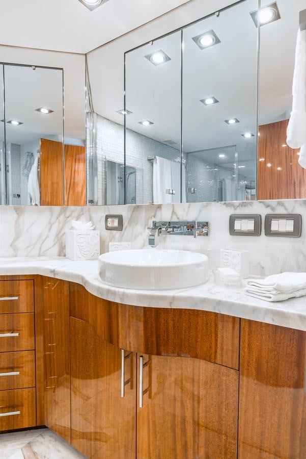 a bathroom with a sink and a mirror aboard HATTERAS 105 Yacht for Sale