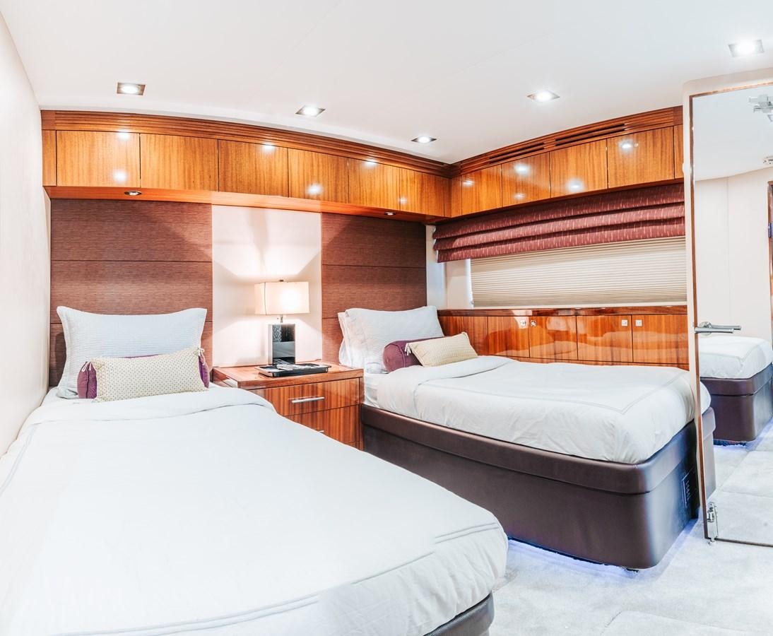 a room with a bed and a lamp aboard HATTERAS 105 Yacht for Sale