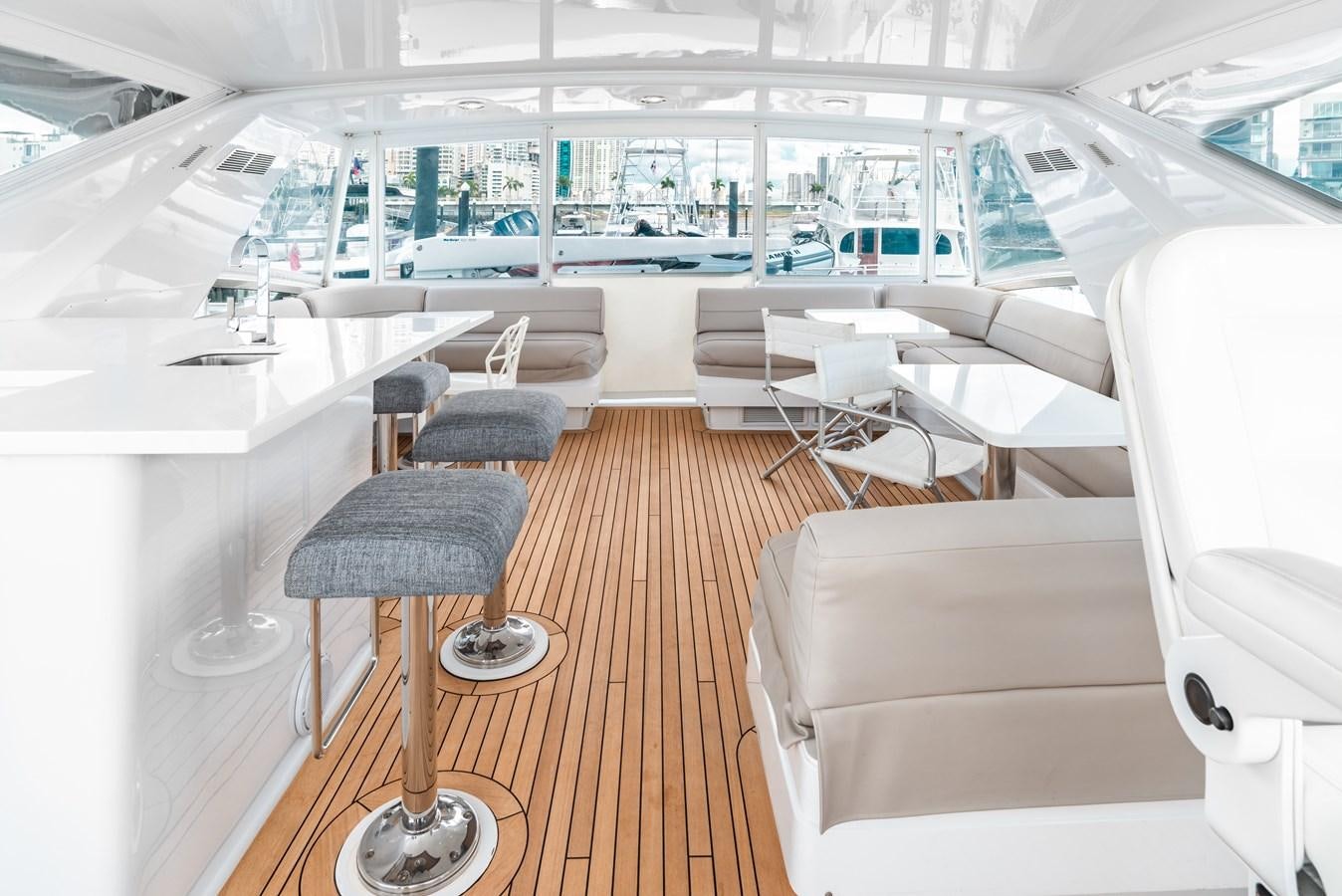 a room with a table chairs and a large window aboard HATTERAS 105 Yacht for Sale