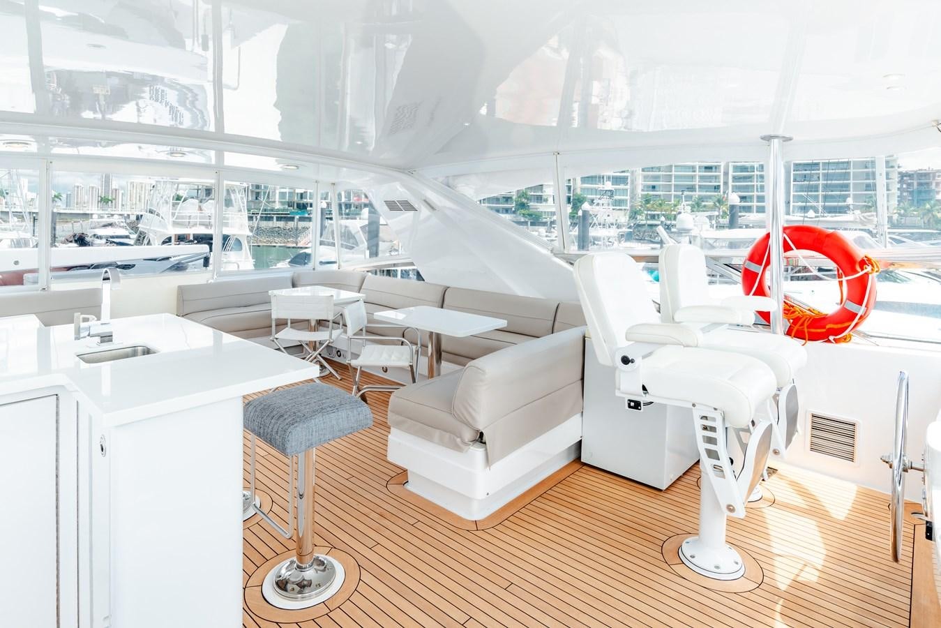 a room with chairs and tables aboard HATTERAS 105 Yacht for Sale