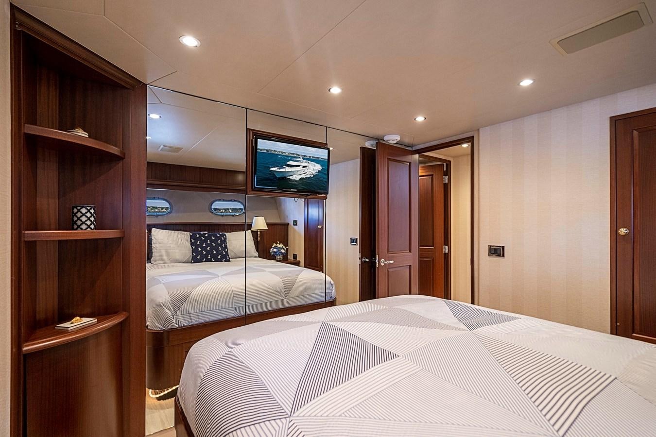 a bedroom with a tv on the wall aboard TRANQUILITY Yacht for Sale