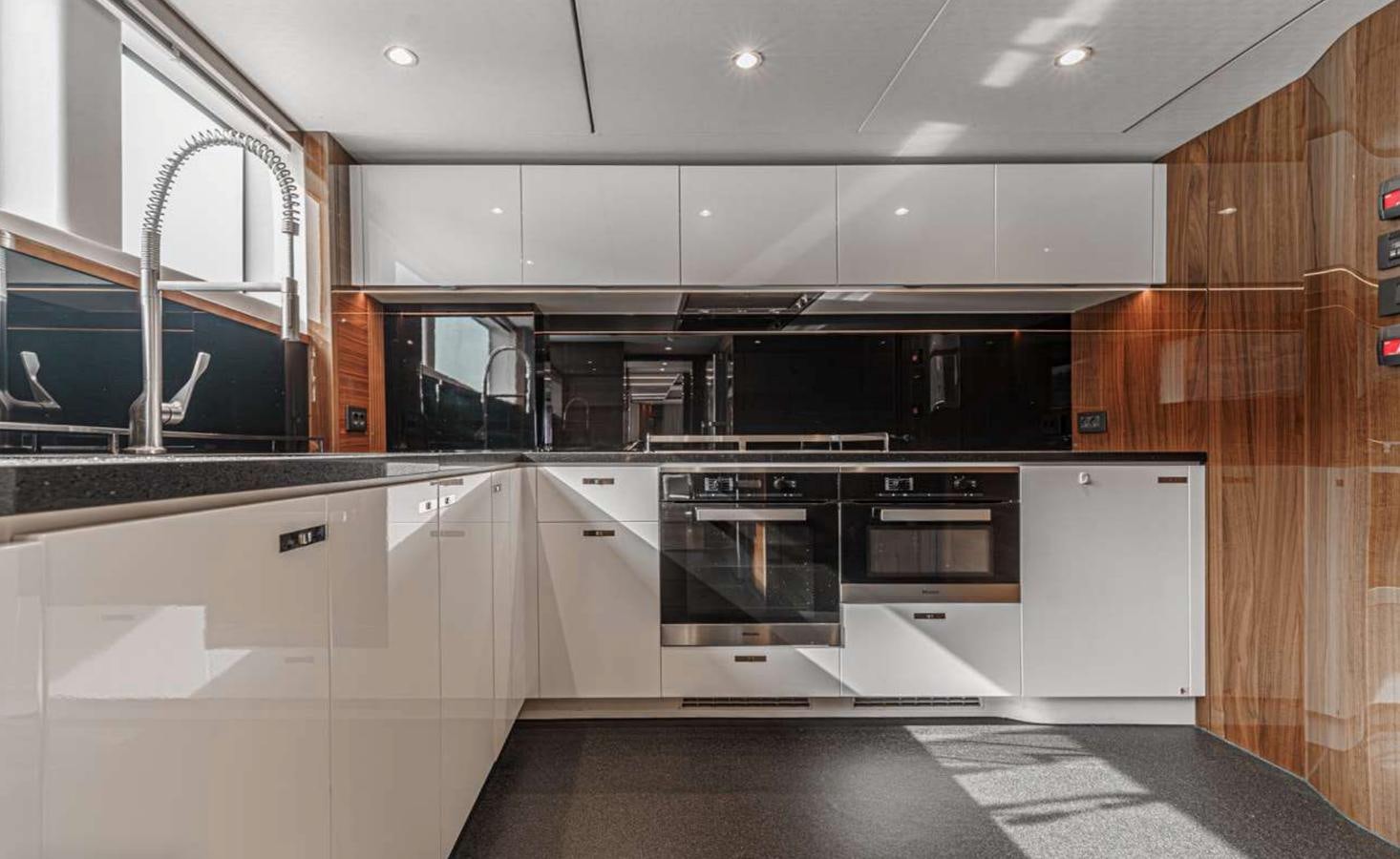 a kitchen with black and white appliances aboard PRINCESS 35M AVALON Yacht for Sale