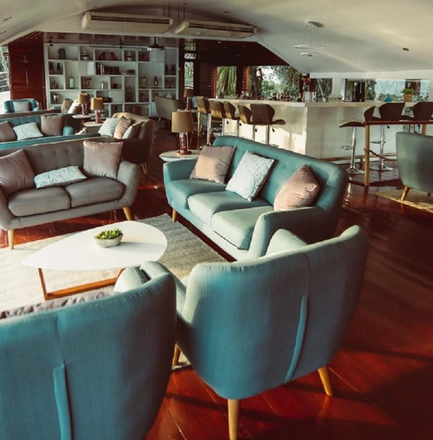 a room with a couch and a table aboard CRUCERO AMAZONAS Yacht for Sale