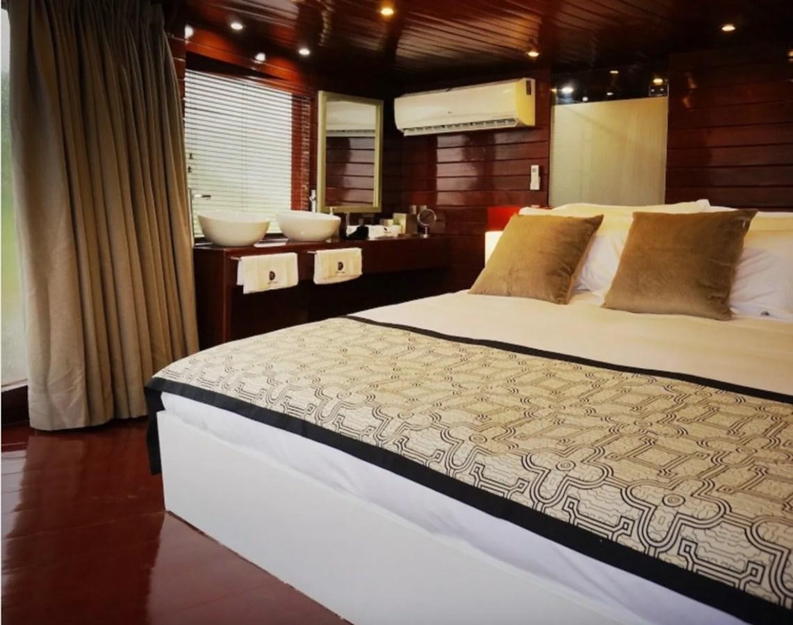 a bed with a white sheet aboard CRUCERO AMAZONAS Yacht for Sale