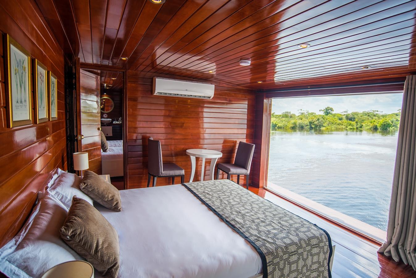 a bed and a table in a room aboard CRUCERO AMAZONAS Yacht for Sale