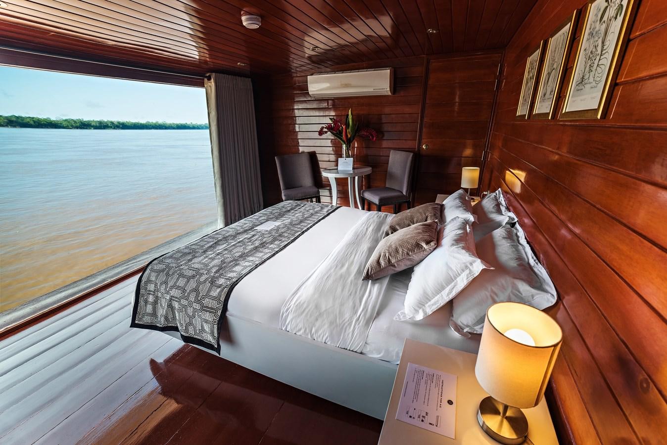 a bed with a pillow on it aboard CRUCERO AMAZONAS Yacht for Sale